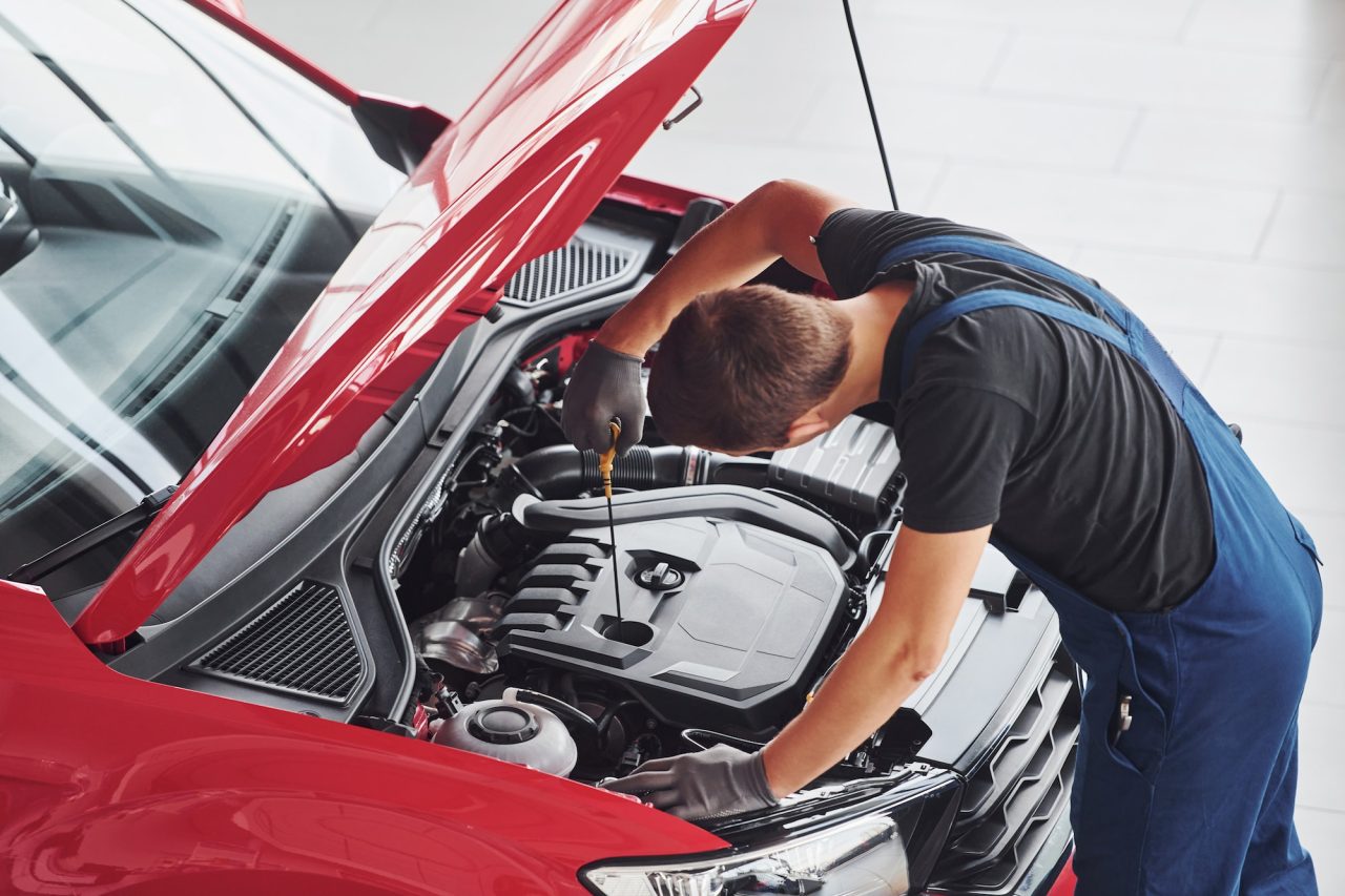 top-view-of-male-worker-in-uniform-that-repairs-red-automobile.jpg